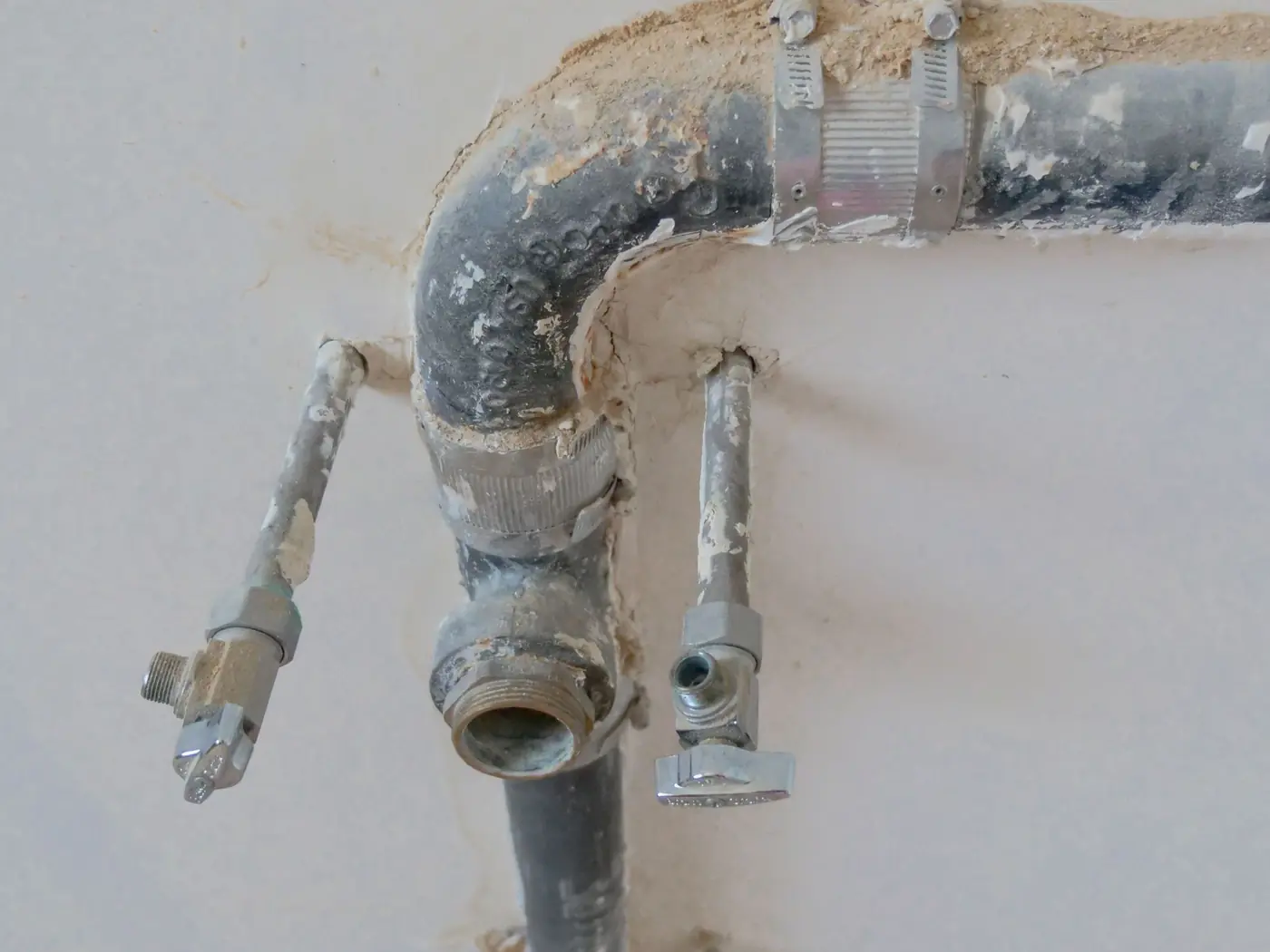 Freigelegte Rohrleitung in einer Wand